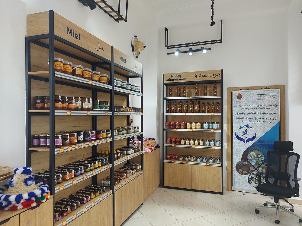 Boutique de produits du terroir au Maroc : une étagère entière de miels en pots, à côté des huiles alimentaires ; c'est là, et chez l'épicier, que le miel d'une coopérative rencontre ses concurrents.