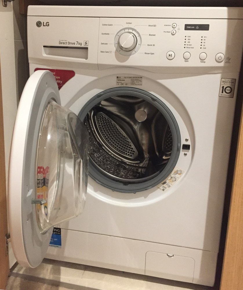 Un lave-linge à chargement frontal, hublot ouvert : on voit le tambour qui reçoit le linge et, en haut, le bouton de programmation et l'afficheur. Ce que l'on demande à l'appareil (laver, essorer, vidanger, se raccorder à la maison) devient les exigences du diagramme. Cet appareil accepte 7 kg de linge ; le diagramme étudié fixe 5 kg.